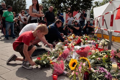 Ciudadanos ponen flores y velas en el exterior del centro comercial donde tuvo lugar el tiroteo.