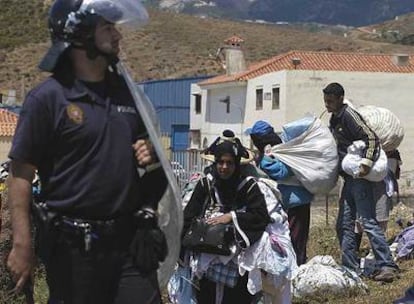 Un policía local desaloja a un grupo de personas de la zona en la que ayer murieron dos mujeres.