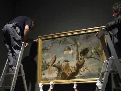 Un grupo de operarios, con un cuadro del Museo del Prado. 