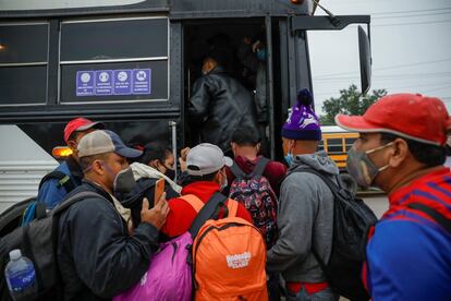 Un grupo de migrantes se sube a un autobús en la localidad hondureña de Cofradía como parte de la nueva caravana.