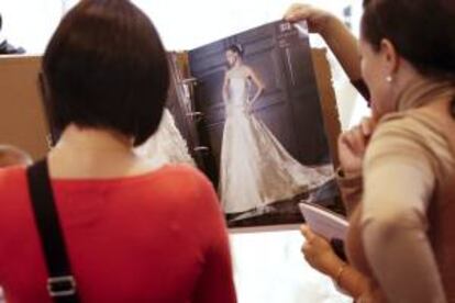 Dos mujeres observan unos catálogos de vestidos de novias. EFE/Archivo