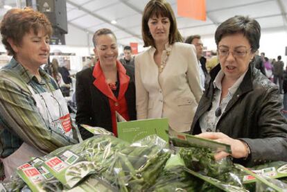 Una agricultora muestra sus productos en la feria bilbaína a la consejera de Agricultura, Pilar Unzalu; la portavoz del Ejecutivo, Idoia Mendia, y la directora de Turismo, Isabel Muela (de derecha a izquierda).