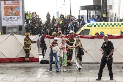 La primera ministra danesa, Mette Frederiksen, ha emitido un comunicado al filo de la pasada medianoche en el que ha calificado el suceso de “brutal ataque”. En la imagen, los servicios de emergencia asisten a las personas que salen del centro comercial.