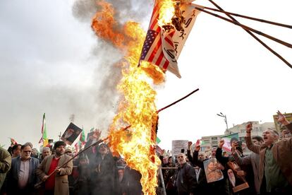 Un grupo de manifestantes queman banderas estadounidenses durante una manifestación en Teherán (Irán).