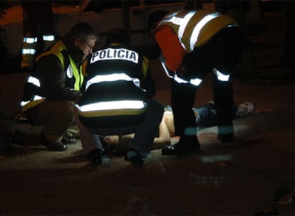 Agentes de policía examinan el cadáver de Jimmy Junior Ureña, apuñalado por una banda de Latin King el 4 de noviembre de 2005.
