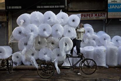 Un trabajador indio carga mercancías en una bicicleta en Nueva Delhi (India).