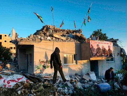 Palestinos nos restos da casa de Qassam Barghouti, demolida pelas forças israelenses na Cisjordânia, na segunda.