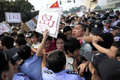 Trabajadores de la fábrica japonesa Meiko Electronics enfrentándose el pasado 19 de septiembre con la policía durante una marcha en Wuhanpara defender la soberanía china sobre las Islas Diayou, conocidas como Islas Senkaku en Japón. EFE/Shepherd Zhou/Featurechina