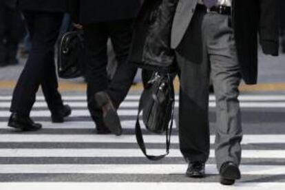 Hombres de negocios cruzan un paso de peatones en Tokio (Japn).