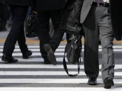 Hombres de negocios cruzan un paso de peatones en Tokio (Japón).