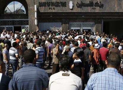 Decenas de palestinos hacen cola frente a un banco para sacar dinero en el centro de la Ciudad de Gaza este jueves antes de que la tregua humanitaria venciera a las dos de la tarde hora peninsular en España