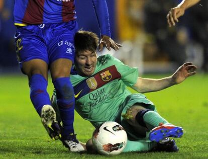 Turf war: Leo Messi battling for the ball with a Levante defender on Saturday.