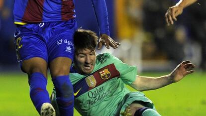 Turf war: Leo Messi battling for the ball with a Levante defender on Saturday.