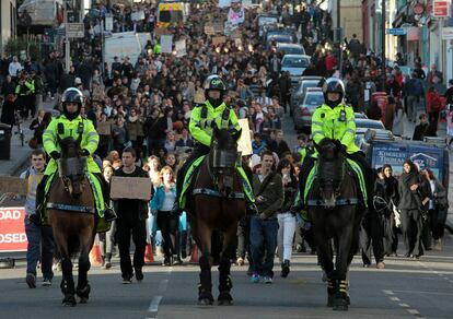 Policías a caballo conducen la manifestación estudiantil contra la subida de las tasas.