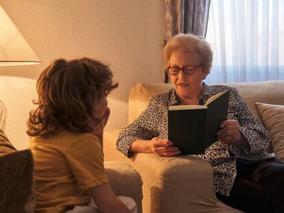 Una abuela le lee un libro a su nieto.