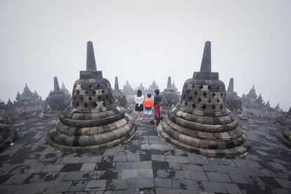 Cada año, a finales de primavera, cuando la luna llena se alinea con la constelación de Tauro, millones de budistas en todo el mundo celebran la fiesta del Vesak, que conmemora el nacimiento, iluminación y muerte de Siddharta Gautama, Buda. Este año, el plenilunio que marca el Vesak se dio en la noche del 1 al 2 de junio, fecha de la foto, tomada en una de las terrazas superiores del gigantesco templo budista de Borobudur, en Java (Indonesia). Borobudur, “el más bello monumento de Asia", según Mircea Eliade, fue erigido en el siglo VIII por los soberanos javaneses de la dinastía Sailendra. Su construcción en forma de montaña es una representación del universo budista . Los dos kilómetros y medio de corredores que conducen a la cima, cubiertos de bajorrelieves, no permiten ver las terrazas superiores que aparecen en la fotografía entre la bruma matinal, de forma que la iniciación se produce de manera gradual, en una meditación ininterrumpida.