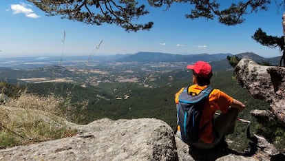 Una mujer contempla una impresionante panorámica de la sierra de Guadarrama, en un alto en el sendero Gr-10, a la altura de la localidad madrileña de Cercedilla.