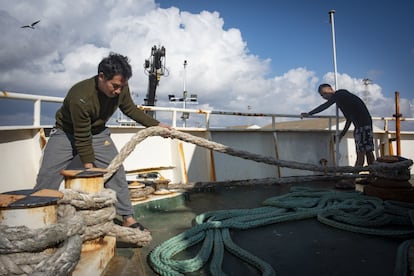 Than Htike (izquierda) y Nyo Tun Lwin, recogen un cabo desde la cubierta del barco.