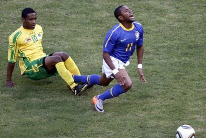 Quincy (Zimbabue) zancadillea a Robinho (Brasil) durante el partido amistoso disputado ayer.