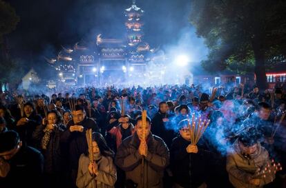 Los asistentes rezan mientras encienden inciensos en el templo Longhua de Shangai (China).