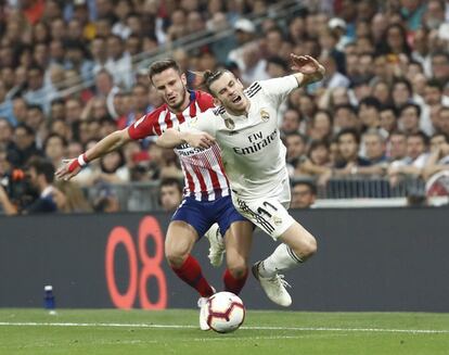 Gareth Bale, a la derecha, cae al suelo durante una jugada con Saúl.