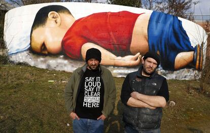 Los artistas Justus Becker, a la derecha, y Oguz Sen este jueves frente al grafiti de Aylan en Fráncfort.