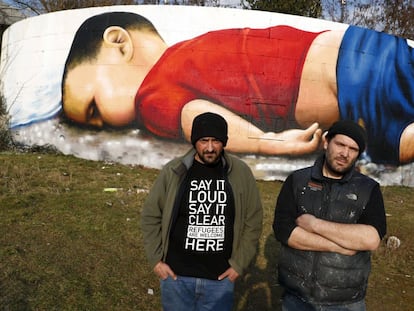 Los artistas Justus Becker, a la derecha, y Oguz Sen este jueves frente al grafiti de Aylan en Fr&aacute;ncfort.