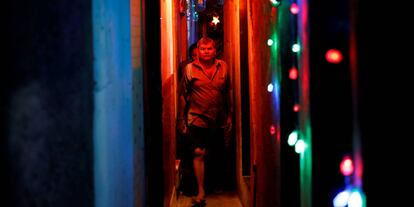 Residentes caminan por un callejón de tugurios iluminado por luces de colores en la víspera del festival hindú de Diwali, en Mumbai (India).