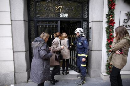 Un bombero deja a los vecinos del número 27 coger sus pertenencias básicas.