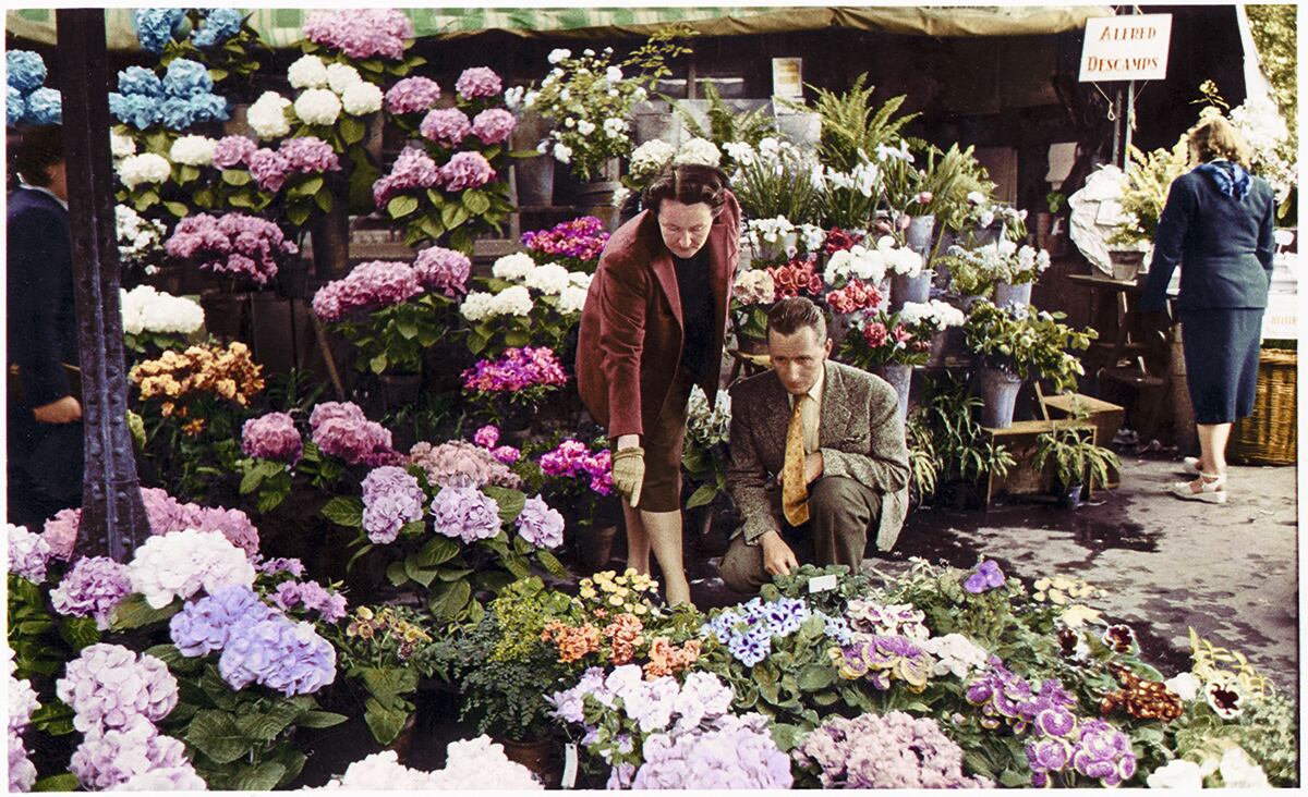 Catherine Dior y su compañero, Hervé des Charbonneries, en 1957, entre ramos en el puesto que ambos regentaron en el mercado de Les Halles.