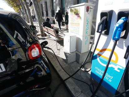 Un conductor carga su coche en un punto de recarga para vehículos eléctricos en el centro de Madrid, este miércoles.