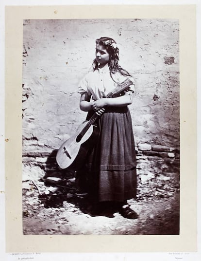 Mujer con guitarra a la puerta de su casa.