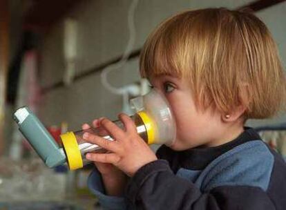 Una niña inhala un medicamento contra el asma mediante una aerocámara.