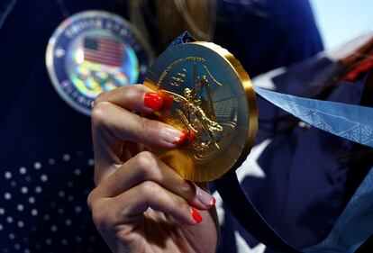 La medallista de oro Torri Huske de Estados Unidos sostiene su medalla mientras celebra su victoria.