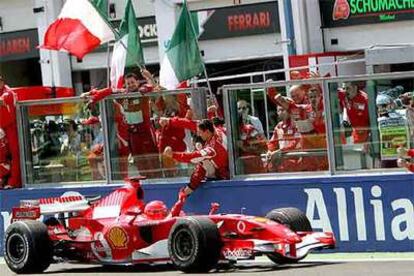 Michael Schumacher celebra con sus mecánicos la victoria en Magny Cours.