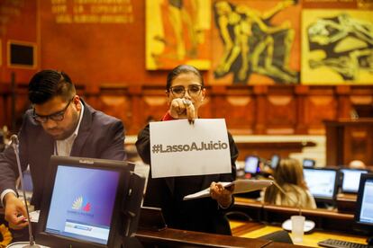 Una mujer sostiene un papel en el que se lee Lasso a juicio, en la Asamblea Nacional de Ecuador, este sábado.