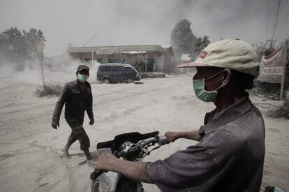 Los aldeanos de Beras Tepu, Indonesia, se protegen con máscaras de las cenizas arrojadas desde el Monte Sinabung, en la provincia del Norte de Sumatra, Indonesia. Más de 26.000 aldeanos han sido evacuados desde que las autoridades elevaron el nivel de alerta por el volcán al nivel más alto en noviembre de 2013.