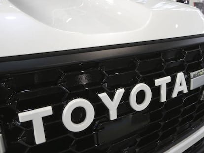 Una persona camina junto a un vehículo de Toyota en Tokyo.