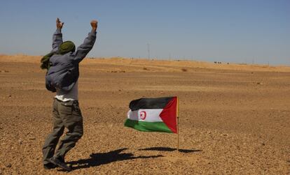 Un miembro del Frente Polisario en Tinduf (Argelia) se manifiesta ante los soldados marroquíes, al fondo de la imagen.