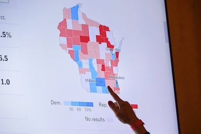 A supporter of Wisconsin Republican gubernatorial candidate Tim Michels points to the incoming state-wide data of the Wisconsin governor's race during an election night campaign event for Michels at the Italian Community Center, Nov. 8, 2022, in Milwaukee.