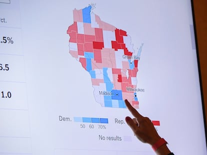 A supporter of Wisconsin Republican gubernatorial candidate Tim Michels points to the incoming state-wide data of the Wisconsin governor's race during an election night campaign event for Michels at the Italian Community Center, Nov. 8, 2022, in Milwaukee.