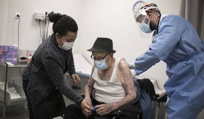 El doctor Gerard Suárez atén en Rafael, de 96 anys, que ha anat al centre acompanyat de la seva cuidadora, l'Ana.