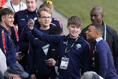 Kylian Mbappé se fotografía con un grupo de jóvenes aficionados durante el entrenamiento del pasado 13 de junio. 