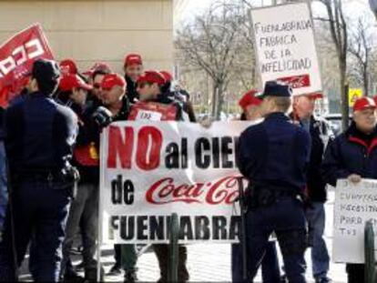 Trabajadores de Coca Cola portan pancartas durante una concentración llevada a cabo en las inmediaciones de la Asamblea de Madrid para exigir a la empresa que dé marcha atrás en sus planes para cerrar su planta de Fuenlabrada. EFE/Archivo