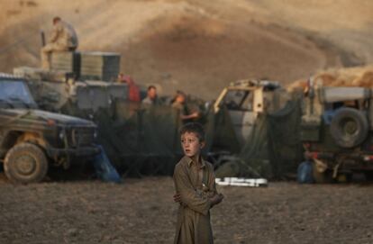 14 de septiembre de 2009. Un niño afgano observa como soldados alemanes de la ISAF preparan un campamento temporal para pasar la noche durante un patrullaje de largo plazo en la región montañosa de Faisabad, al este de Kunduz, Afganistán.