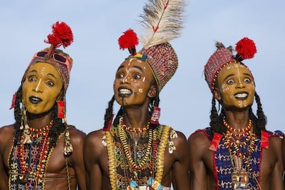 La tribu nómada de los wodaabes apacienta el ganado en el desierto del Sahel, desde el norte de Camerún hasta Chad, Níger y el noreste de Nigeria. Cruzan países desgarrados por la sequía, la pobreza y la guerra, cobijándose en las estructuras más básicas con sus escasas posesiones, y dependen por completo de sus animales para sobrevivir. Pero, a pesar de la dureza de su entorno, lo que más aprecian los wodaabes es la belleza, y una vez al año, los hombres visten elaborados trajes, se maquillan el rostro y bailan durante horas con la esperanza de encontrar el amor. No es el lugar en el que uno esperaría encontrar personas obsesionadas por la estética. Pero cuando acaba la estación lluviosa, se reúnen para celebrar la belleza en el Gerewol, una ceremonia de cortejo de una semana, que da la vuelta a las nociones occidentales de política sexual. La de los wodaabes debe de ser de las pocas culturas africanas que permiten a las chicas tomar la iniciativa y escoger prometido; e incluso las casadas tienen derecho a tomar como compañero a un hombre distinto. En esta imagen, tres hombres wodaabes efectúan su danza ritual, el yaake, como parte del Gerewol.