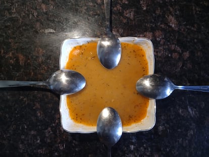 Sopa de lentejas con cuatro cucharas para compartir.