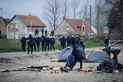 Agentes de policía sacan a migrantes de un campamento en Calais (Francia) el 28 de noviembre