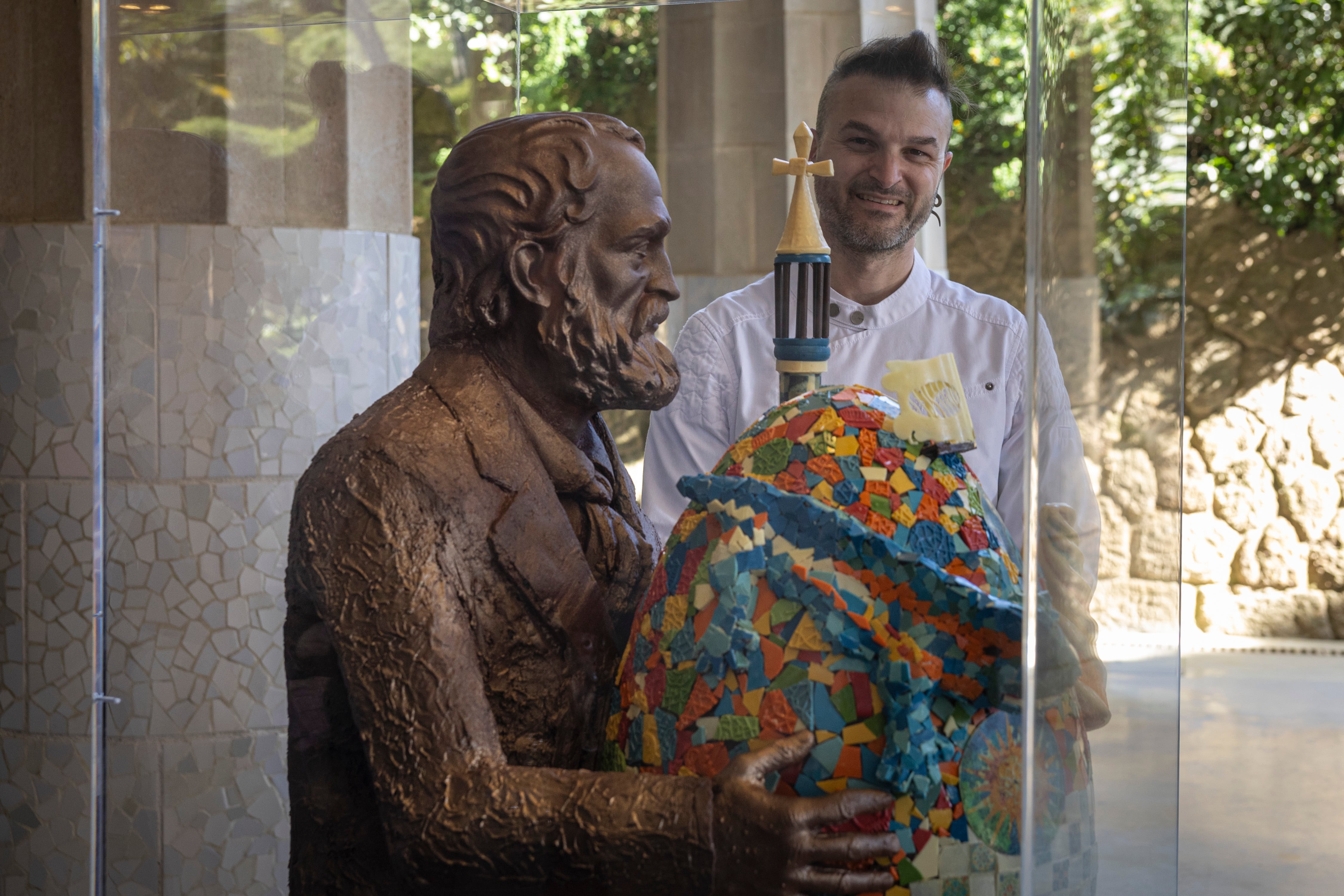 Exposición 'Gaudí en xocolata' reúne a 10 maestros pasteleros, que reinterpretan la obra de Gaudí en forma de huevos de Pascua, en el Park Güell.  En la imagen, el pastelero Adan Saez frente a su creación.