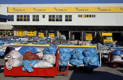 Decenas de sacas con envíos postales acumulados en el patio de las instalaciones de Correos en la terminal de carga del aeropuerto de Barajas, en Madrid.